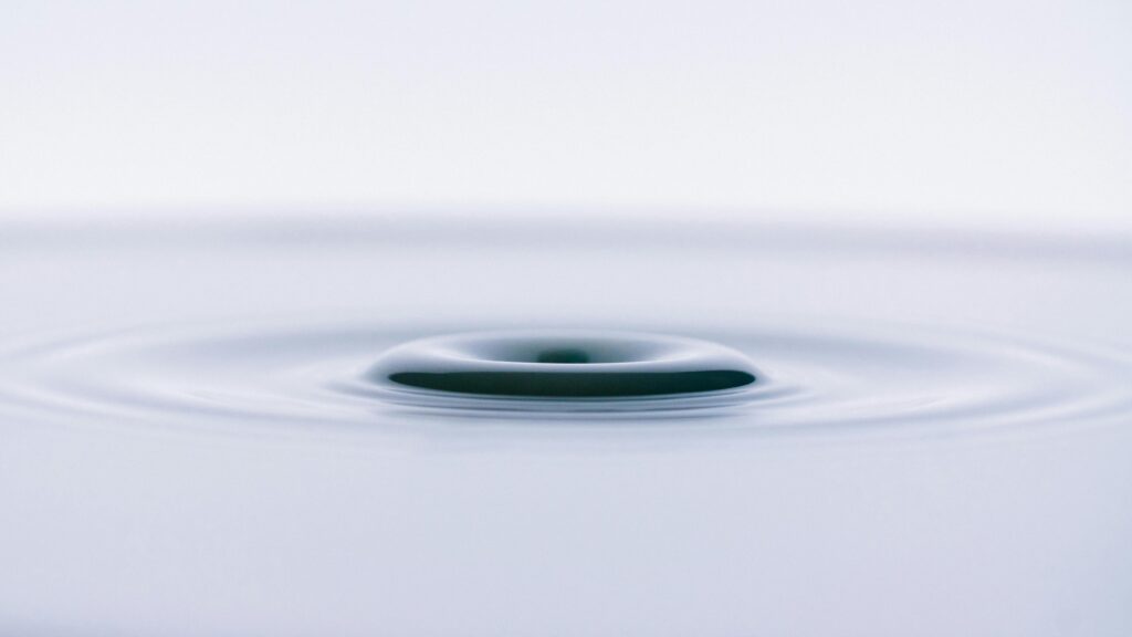 Close-up of a smooth water ripple creating an abstract, minimalist effect.